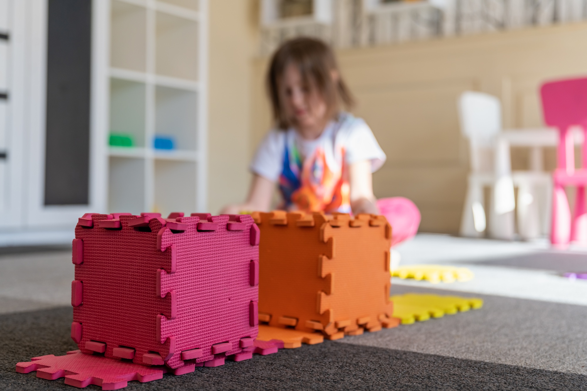 cute little girl playing in the children's room with cubes