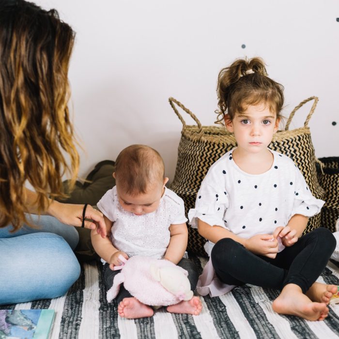 mother_sitting_near_children_striped_rag